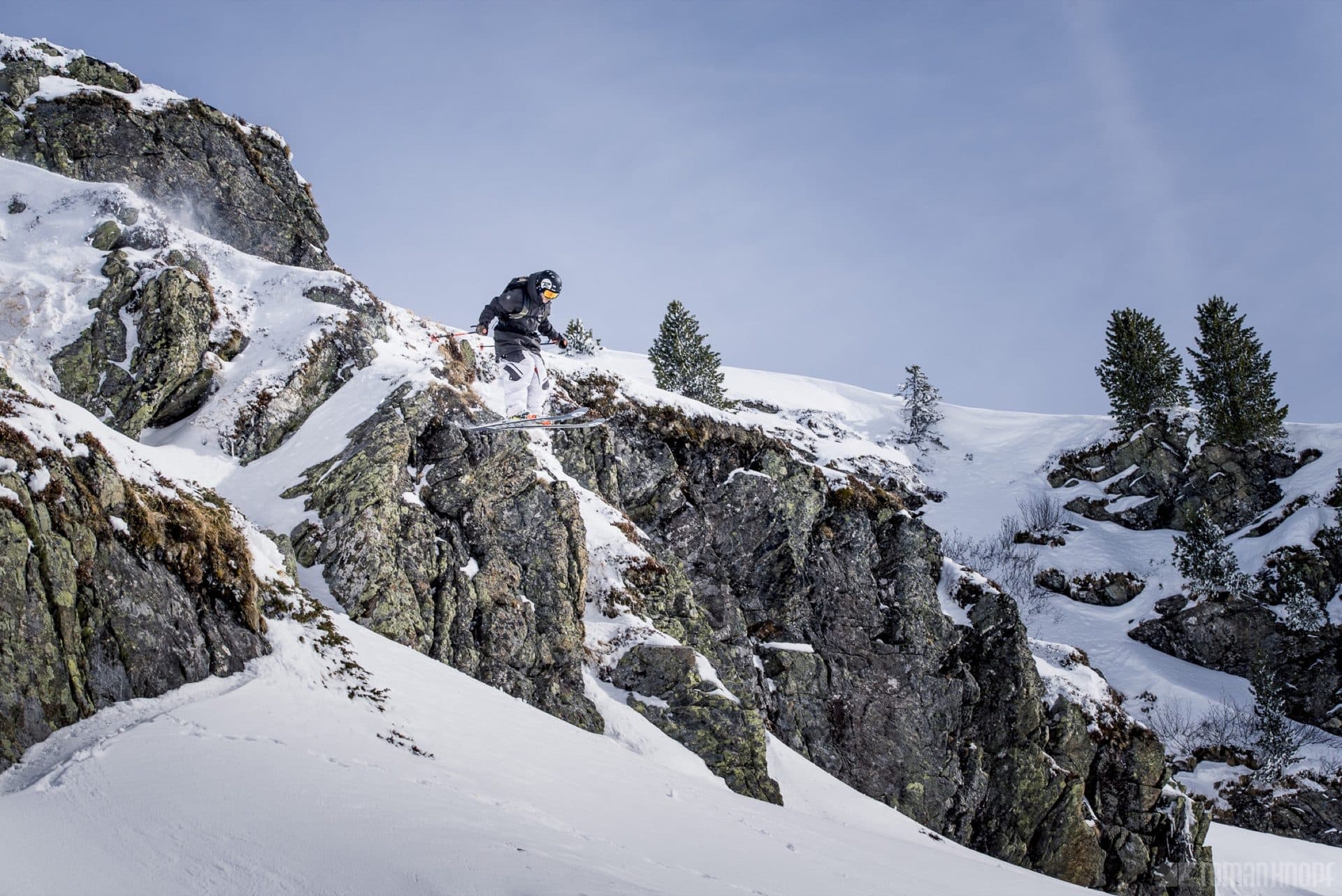 Backcountry skier dropping a cliff in the Wasatch Mountains above Cottonwood Canyon